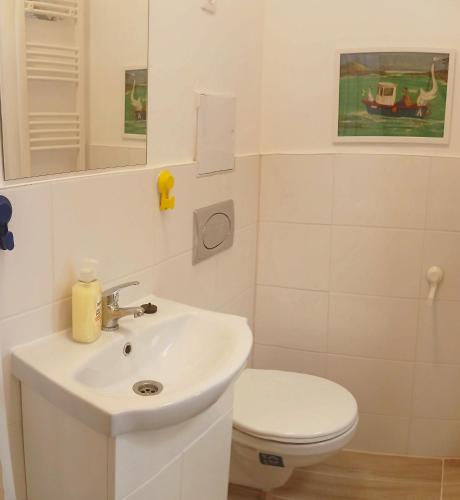 ein Badezimmer mit einem weißen Waschbecken und einem WC in der Unterkunft SaraHome3 Center in Szeged