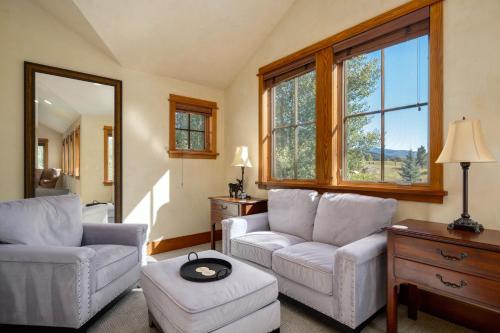 a living room with two white chairs and a table at The Porches in Steamboat Springs