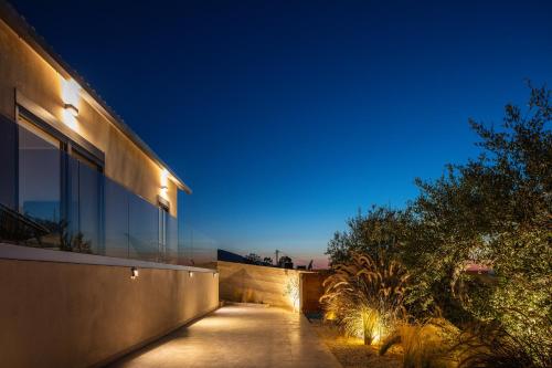 una casa con un sentiero di fronte ad essa di notte di ÉTHAFOS Luxury Apartment a Tsikalariá