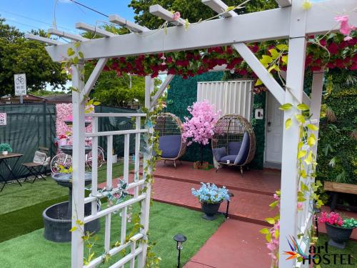 uma pérgola branca com cadeiras e flores em Art Gardens Wynwood concept em Miami