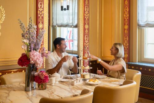 a man and woman sitting at a table in a restaurant at Hotel Cafe Royal in London