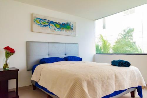 Un dormitorio con una cama con almohadas azules. en P2 Poseidon 5 Stars Ocean View Prestigioso Apartamento 2 Dormitorios, en Manta