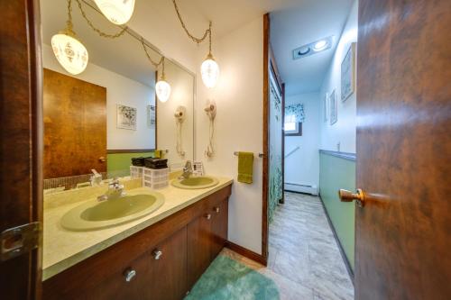 a bathroom with two sinks and a large mirror at Lake Erie Getaway with Private Pool and Yard! in Conneaut