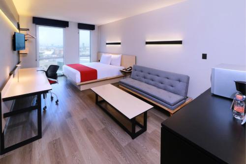 a hotel room with a bed and a desk at City Express by Marriott Monterrey Universidad in Monterrey