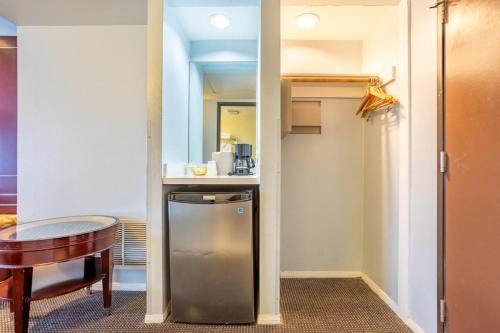 a small kitchen with a table and a refrigerator at Hotel Koxie in Los Angeles