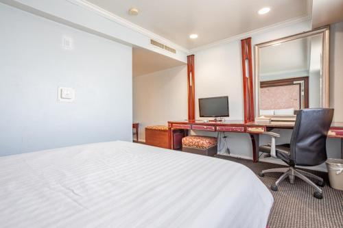 a bedroom with a bed and a desk and a computer at Hotel Koxie in Los Angeles