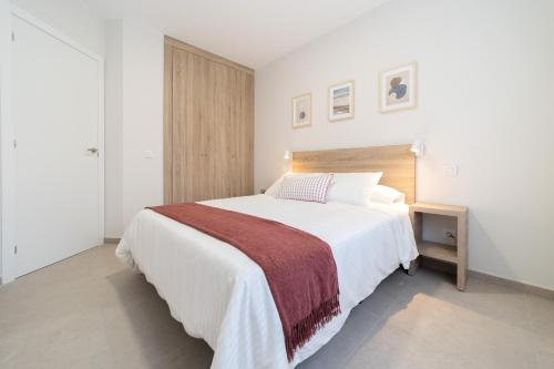 - une chambre avec un grand lit blanc et une couverture rouge dans l'établissement Venegas Urban Suites By Bevacacional, à Las Palmas de Gran Canaria