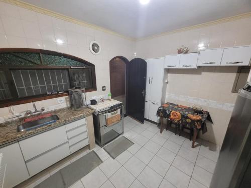 a kitchen with a table and a counter top at Casa linda e confortável a 3 min da praia!!! in Peruíbe