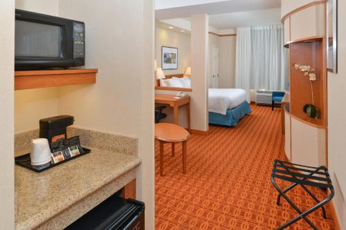 a hotel room with a bed and a room at Fairfield Inn and Suites by Marriott Elk Grove in Elk Grove