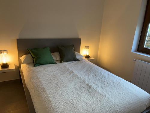 a bedroom with a large bed with green pillows at APARTAMENTOS EL ROJU in Santillana del Mar