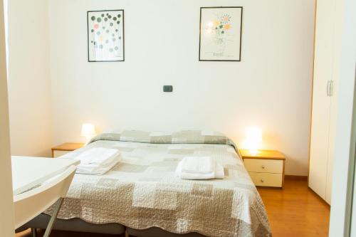 a white bedroom with a bed and a sink at Alloggio Cavour in Ferrara