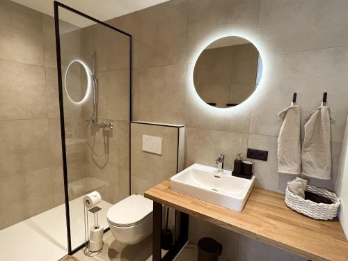 bagno con lavandino, servizi igienici e specchio di Ferienwohnung Natters - Your vacation base a Innsbruck