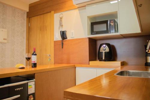 a kitchen with a sink and a microwave at Flat 333 - Luxo e Vista da Pedra Azul in Pedra Azul