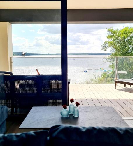 a table with a view of the water from a house at Apartamenty Boszkowo Horizon Sunset in Boszkowo