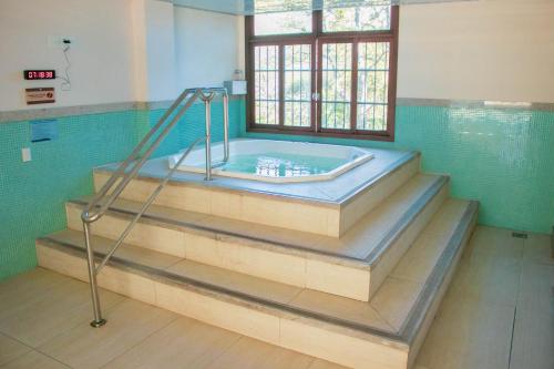 a jacuzzi tub in a bathroom with a window at Flat 333 - Luxo e Vista da Pedra Azul in Pedra Azul