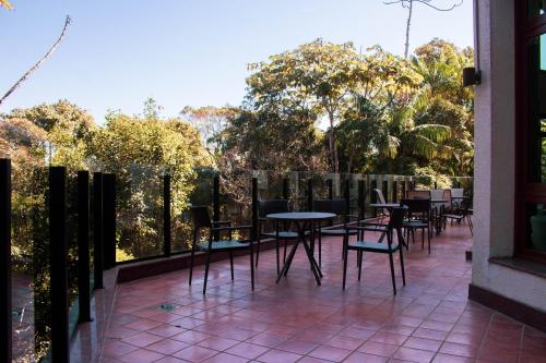a patio with tables and chairs on a balcony at Flat 333 - Luxo e Vista da Pedra Azul in Pedra Azul