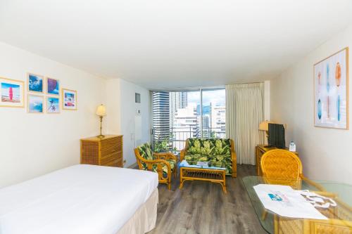 Una habitación de hotel con una cama y una sala de estar. en Ilikai Marina 1495 City View Studio, en Honolulu