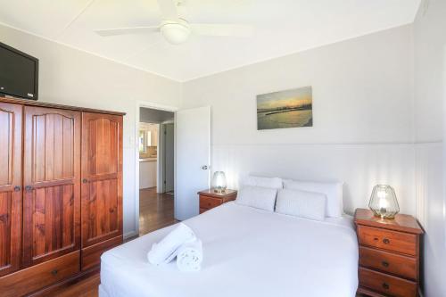 a bedroom with a white bed and a tv at Reflections Tuncurry - Holiday Park in Tuncurry