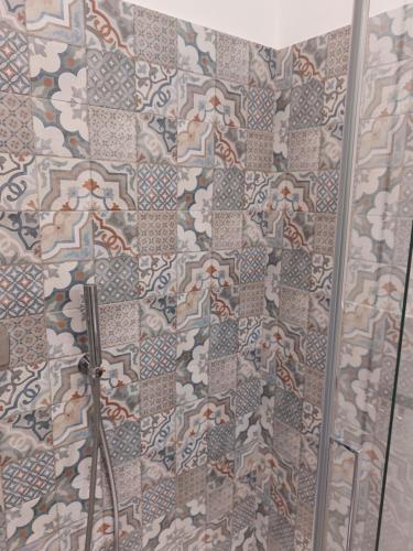 a shower with a mosaic tile wall in a bathroom at Appartamento Piazzetta La Maddalena in Savona
