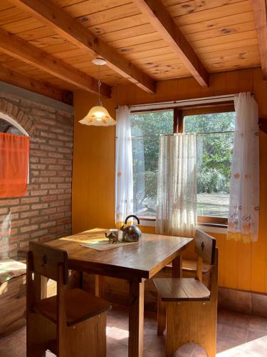 een keuken met een houten tafel, een wastafel en een raam bij Complejo Jardín de Olmos in Villa Giardino
