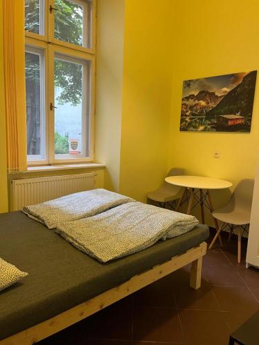 1 dormitorio con cama, mesa y ventana en Batorego Lovely Rooms, en Cracovia