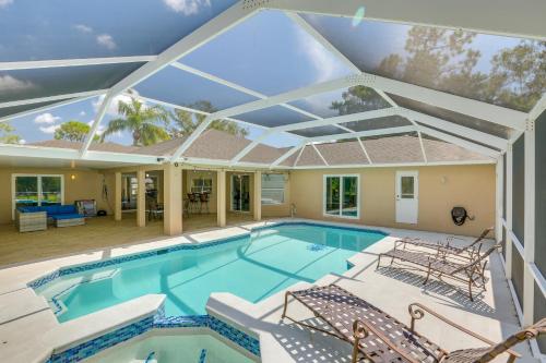 a large swimming pool with a large glass ceiling at Private Fort Myers Escape with Screened Pool and Lanai in Fort Myers