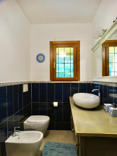 a bathroom with two sinks and a toilet and a mirror at Villa Bel Lago in Bracciano
