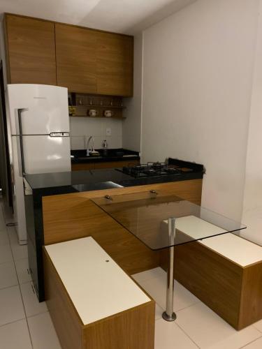 a kitchen with a white refrigerator and wooden cabinets at Flat em Campina Grande in Campina Grande