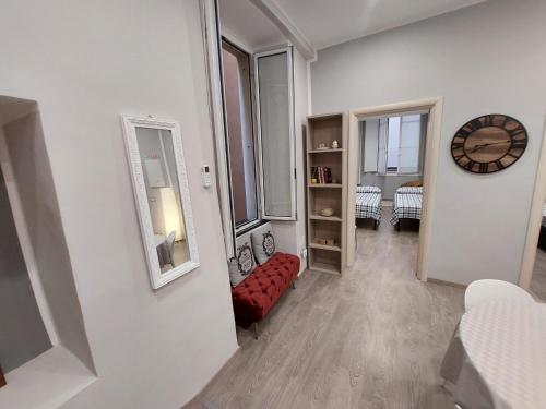 a living room with a red couch and a mirror at Appartamento Piazzetta La Maddalena in Savona