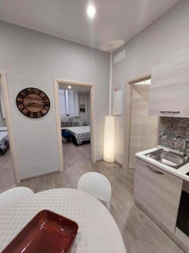 a kitchen with a table and a clock on the wall at Appartamento Piazzetta La Maddalena in Savona