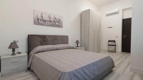 a bedroom with a large bed and two night stands at La Laguna Rooms in SantʼAntìoco