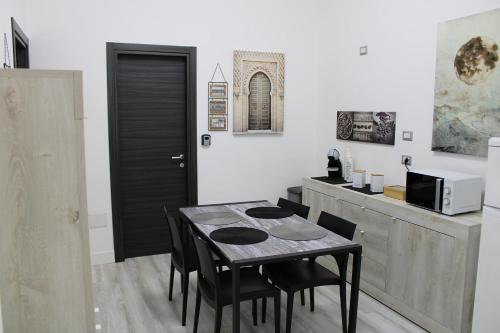 a dining room with a table and chairs and a counter at La Laguna Rooms in SantʼAntìoco