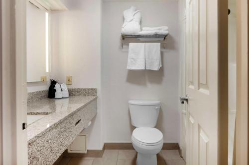 a bathroom with a toilet and a sink with towels at Best Western Milton in Milton