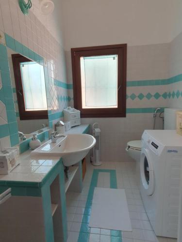 a bathroom with a sink and a washing machine at Casa Evalù in Pula