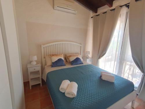 una camera da letto con un letto blu e asciugamani di Casa Evalù a Pula
