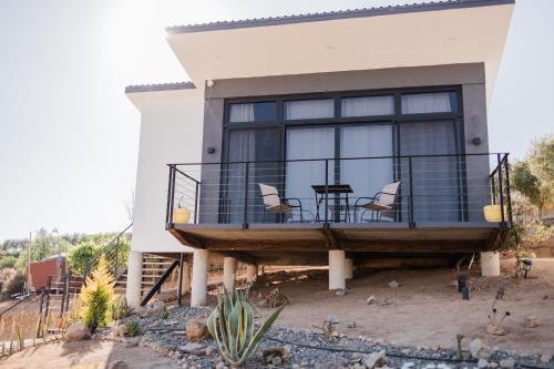 a house with a balcony with a table and chairs at Starlight bungalow queen 4 in El Porvenir