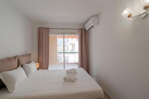 ロクブリュヌ・カップ・マルタンにあるLa Rose des Vents - Sea Viewの窓付きベッドに座るテディベア