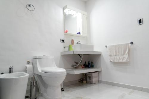 biała łazienka z toaletą i umywalką w obiekcie Departamento en EZEIZA w BuenosAires