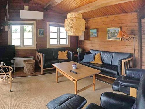 a living room with a couch and a table at 6 person holiday home in R m in Lakolk
