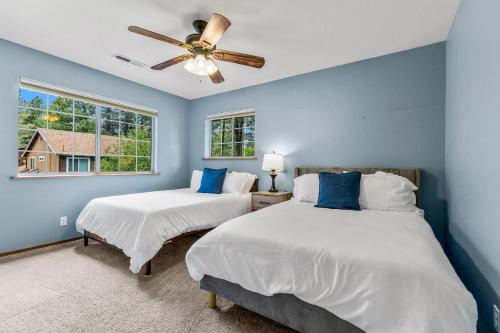 two beds in a bedroom with blue walls and a ceiling fan at Family Friendly Escape~ Close to Downtown ~Airport ~Sedona & Grand Canyon in Flagstaff