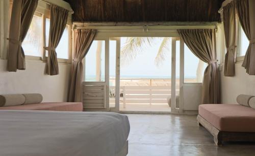 a bedroom with a bed and a view of the ocean at Tuup Oceanfront in Tulum