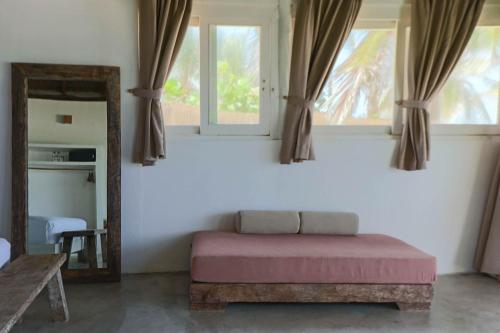 a bedroom with a bed and a mirror and window at Tuup Oceanfront in Tulum