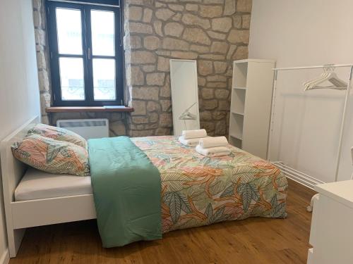 a bedroom with a bed and a stone wall at Private Room in the City Centre in Esch-sur-Alzette