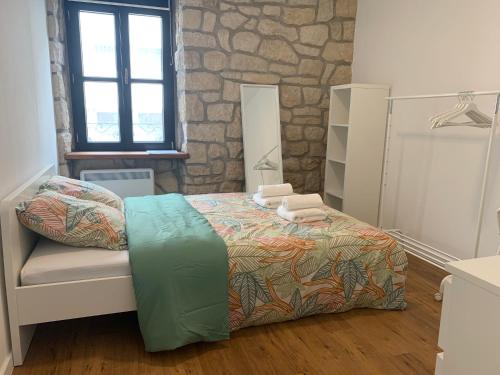 una camera con letto e parete in pietra di Private Room in the City Centre a Esch-sur-Alzette