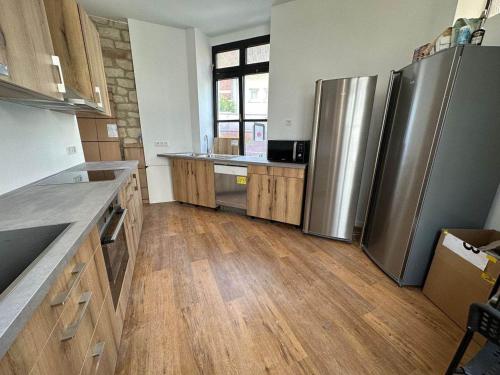a kitchen with stainless steel appliances and wooden floors at Private Room in the City Centre in Esch-sur-Alzette