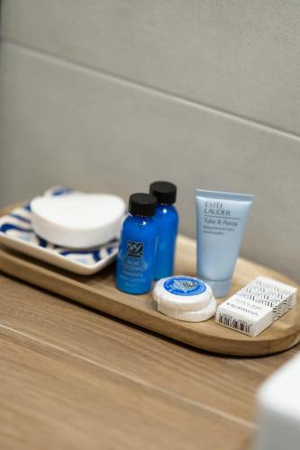 a wooden tray with bottles of soap and a toothbrush at Galazio Seaside Luxury Rooms & Coffee Shop in Platamonas