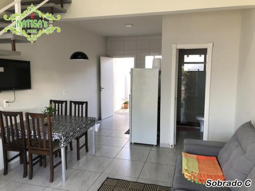 eine Küche und ein Esszimmer mit einem Tisch und einem Sofa in der Unterkunft Sobrados aconchegante com piscina "Natisashouse" in Bombinhas