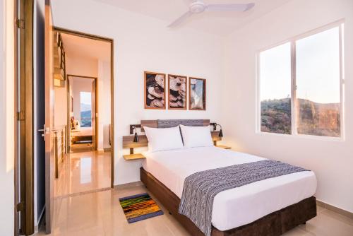 a white bedroom with a bed and a window at XL / Penthouse 150m2 en Terrazas Tayrona 8-10 pax in Gaira