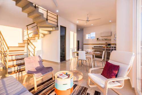 a living room with a spiral staircase and chairs at XL / Penthouse 150m2 en Terrazas Tayrona 8-10 pax in Gaira