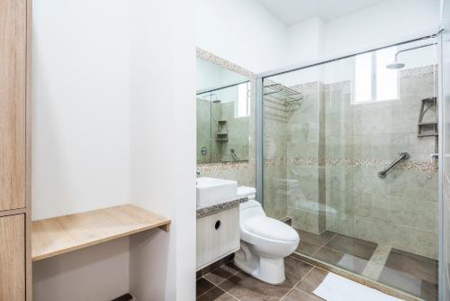 a bathroom with a toilet and a glass shower at XL / Penthouse 150m2 en Terrazas Tayrona 8-10 pax in Gaira